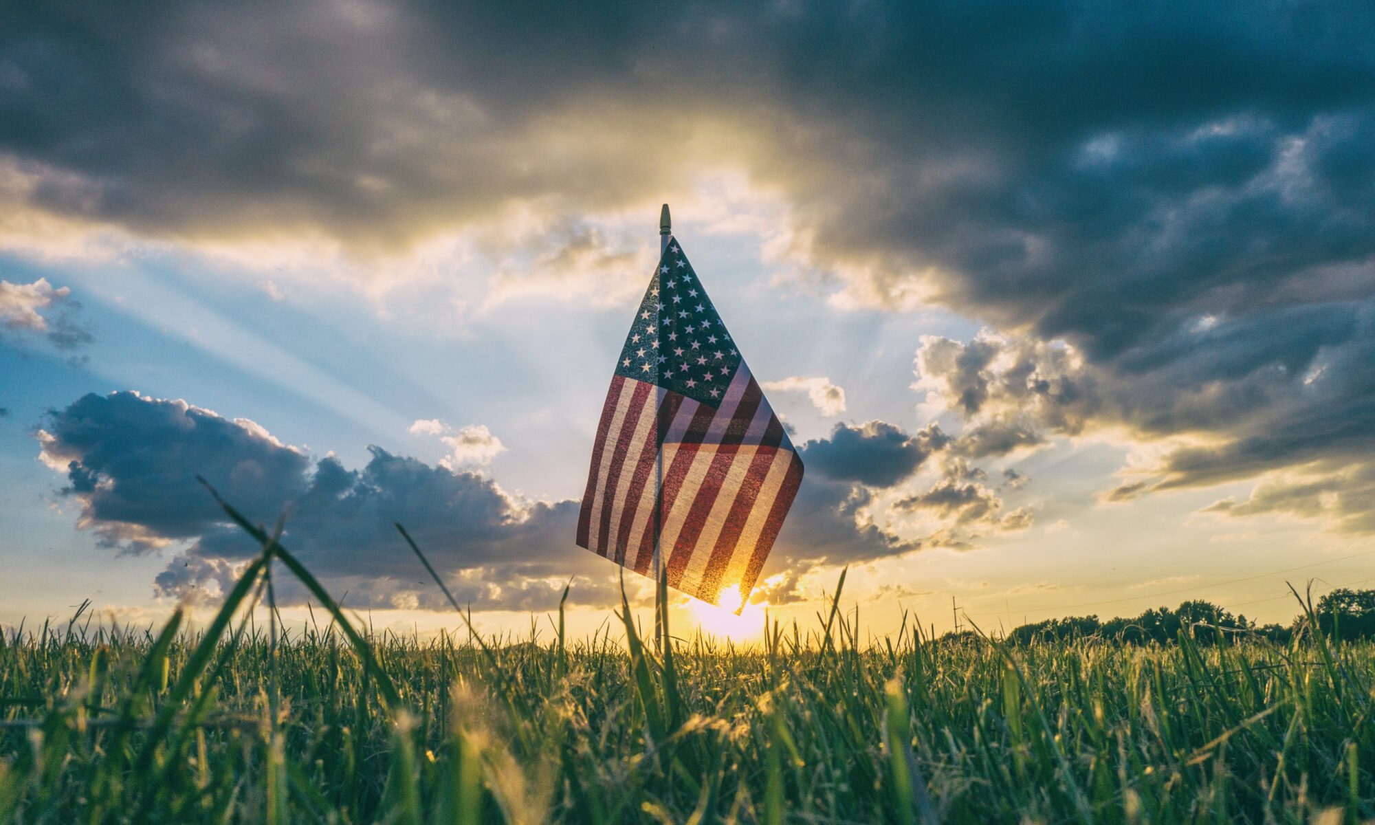 American flag in grass at sunset